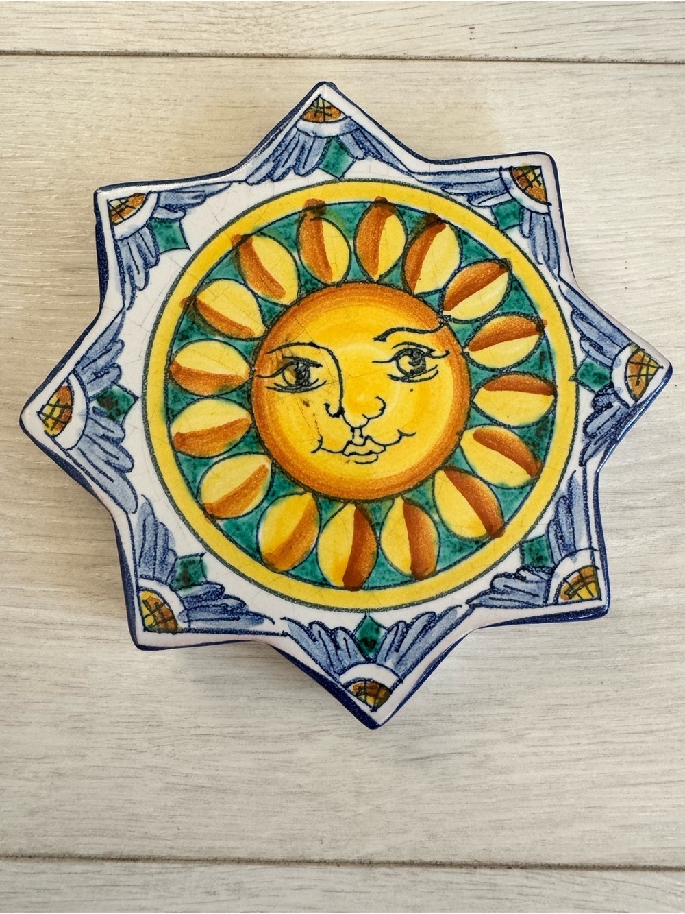 Hand-painted ceramic tile depicting a sun face in star-shape, Italian pottery